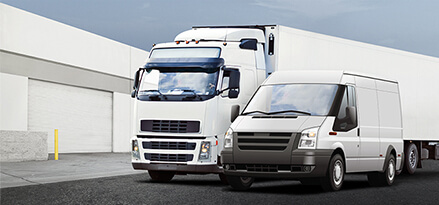two white trucks in front of garage