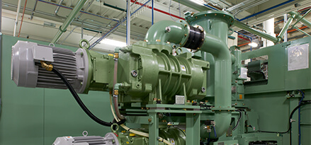 green industrial gearbox inside a plant