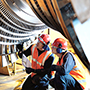 two engineers inspecting turbine from below