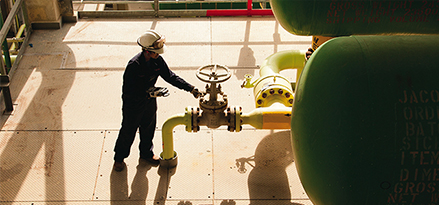 engineer checking hydraulic valve at refinery
