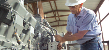 engineer in hard hat checking gas engine