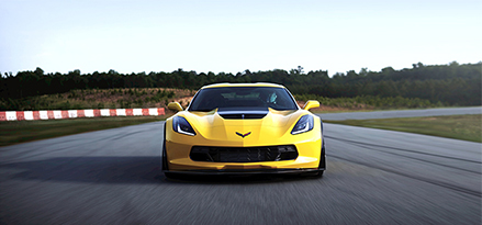 yellow corvette driving on racetrack