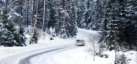 moving white car on a snow road